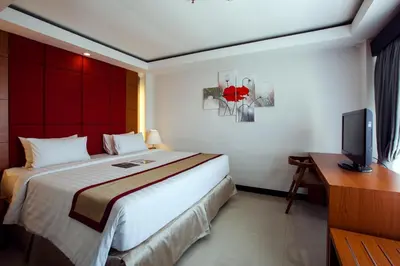 a hotel room with a bed and a television at Royal Regantris Kuta in Kuta