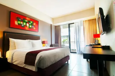 a hotel room with a bed and a television at 100 Sunset Kuta Hotel & Ballroom in Kuta