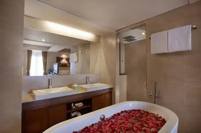 a bathroom with a bath tub and a sink at d'primahotel Seminyak in Seminyak