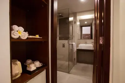 a bathroom with a glass shower and a sink at d'primahotel Seminyak in Seminyak