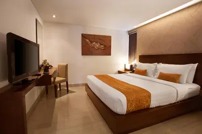 a hotel room with a bed and a flat screen tv at d'primahotel Seminyak in Seminyak