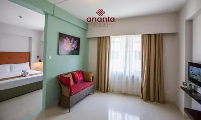 a hotel room with a red chair and a bed at Ananta Legian Hotel in Legian