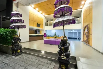 a lobby with purple umbrellas in a building at Quest Hotel Kuta by ASTON in Kuta