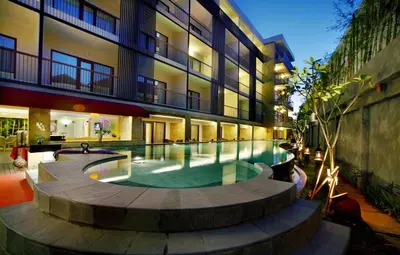 a swimming pool in the middle of a building at Quest Hotel Kuta by ASTON in Kuta