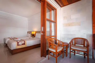 a bedroom with a bed and a desk and a chair at Bali Summer Hotel by Amerta in Kuta