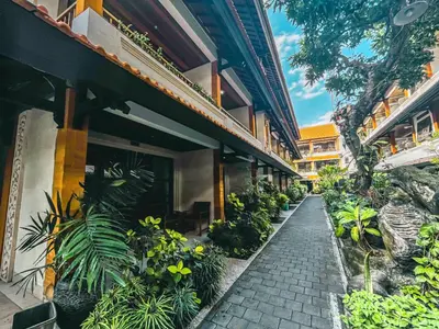 a walkway in front of a building with plants at Bali Summer Hotel by Amerta in Kuta