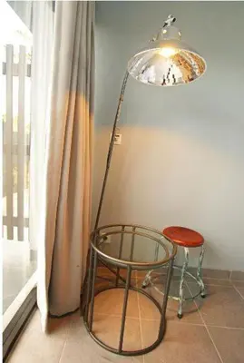 a lamp and a chair next to a window at The Grey Boutique Inn in Legian