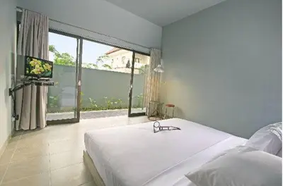 a bedroom with a bed and a large window at The Grey Boutique Inn in Legian