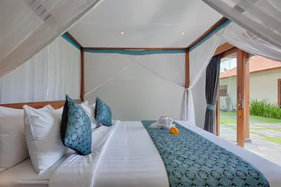 a bed with a teddy bear sitting on top of it at Amore Villas in Canggu