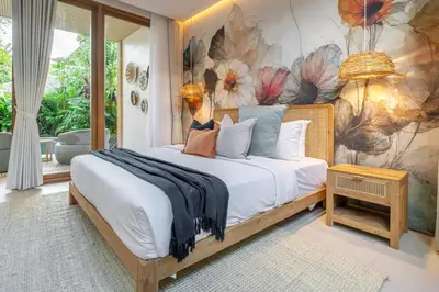 a bedroom with a bed with a floral wall at Villa Esa Seminyak in Seminyak