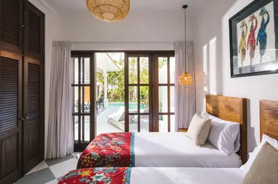 a bedroom with a bed and a sliding glass door at Villa Luma in Seminyak