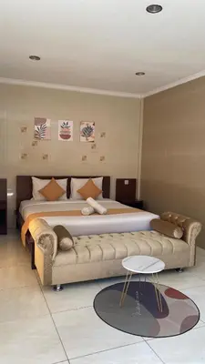 a bedroom with a large bed and a couch at Surya Inn in Kuta