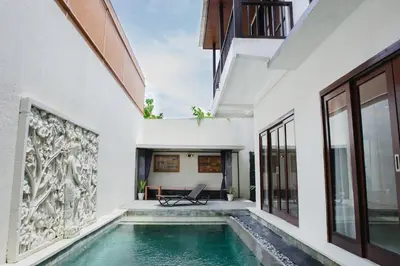 an external view of a house with a swimming pool at White Lotus Villas Seminyak in Seminyak