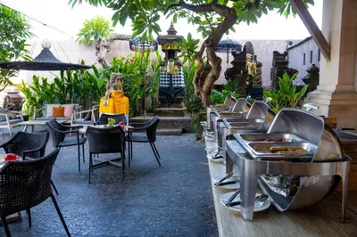 a row of tables and chairs at a restaurant at Puri Raja Hotel in Legian