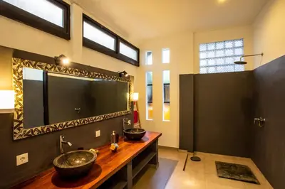a bathroom with a sink and a large mirror at Villa Surga in Seminyak