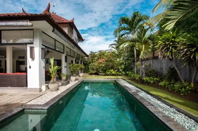 a swimming pool in front of a villa at Villa Surga in Seminyak