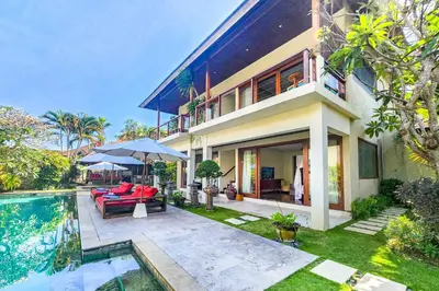 a villa with a swimming pool and a house at Villa Joss Seminyak by Nagisa Bali in Seminyak