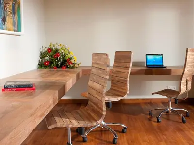 a wooden table with two chairs and a laptop on it at Villa Joss Seminyak by Nagisa Bali in Seminyak