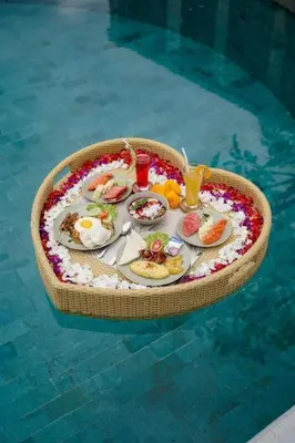 a tray of food on a table in a swimming pool at Villa Joss Seminyak by Nagisa Bali in Seminyak