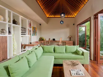 a living room with a green couch and a table at Villa Joss Seminyak by Nagisa Bali in Seminyak