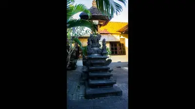 a stone pillar in front of a building at Leyeh Leyeh Homestay in Canggu