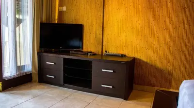 a entertainment center with a flat screen tv in a room at Leyeh Leyeh Homestay in Canggu
