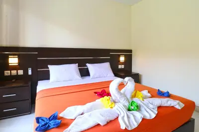 a bedroom with a bed with towels on it at Gempita House Legian Bali in Legian