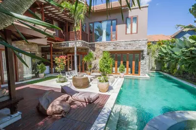 a house with a dog laying next to a swimming pool at Villa Martine - Fantastic 5BR Villa - Perfect Location in Seminyak in Seminyak