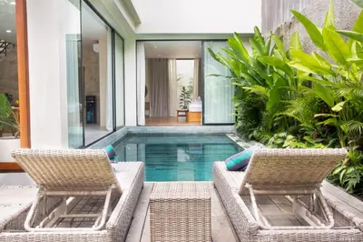 two chairs and a swimming pool in a house at NEW 2BR Minica Villa in the heart of Kayu Aya, Oberoi, Seminyak walking distance to Beach, Shops, Restaurants in Seminyak