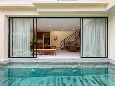 a glass house with a swimming pool in front of it at NEW 2BR Minica Villa in the heart of Kayu Aya, Oberoi, Seminyak walking distance to Beach, Shops, Restaurants in Seminyak