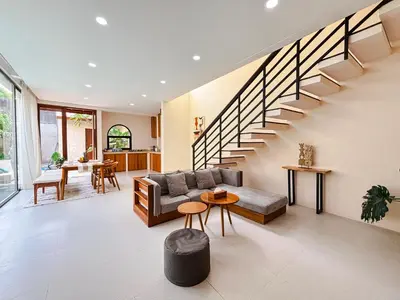 a living room with a couch and a staircase at NEW 2BR Minica Villa in the heart of Kayu Aya, Oberoi, Seminyak walking distance to Beach, Shops, Restaurants in Seminyak