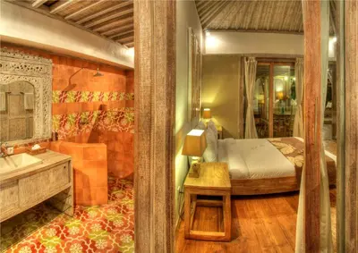 a bedroom with a bed and a sink and a mirror at Villa Layla - Charming 2BR Villa in Oberoi - Prime Location! in Seminyak