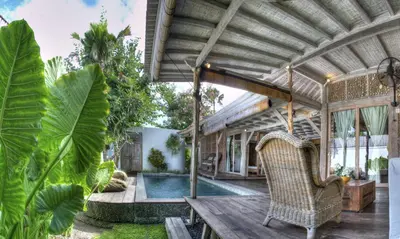 an outdoor patio with a table and chairs and a pool at Villa Layla - Charming 2BR Villa in Oberoi - Prime Location! in Seminyak