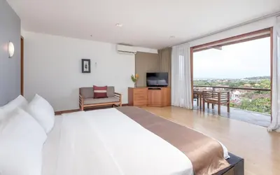 a bedroom with a large bed and a large window at Villa Hening Jimbaran in Jimbaran