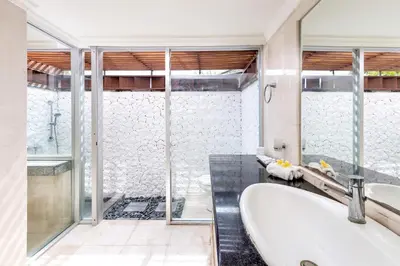 a bathroom with a tub and a sink and a shower at Villa Hening Jimbaran in Jimbaran