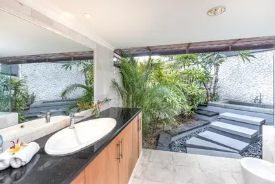 a bathroom with a sink and a bath tub at Villa Hening Jimbaran in Jimbaran