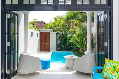 an outdoor patio with chairs and a table at Villa Neno in Seminyak
