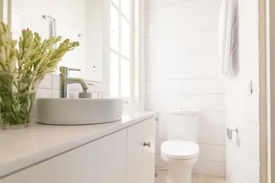 a white bathroom with a sink and a toilet at Villa Neno in Seminyak