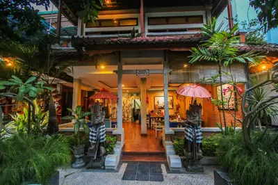 a restaurant in a resort with tables and umbrellas at Legian Village Hotel - CHSE Certified in Legian