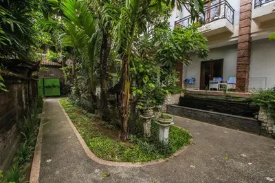 a building with palm trees in front of it at Legian Village Hotel - CHSE Certified in Legian