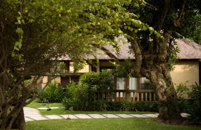 a house with a fence and a tree at Villas at The Patra Bali Resort and Villas - CHSE Certified in Kuta