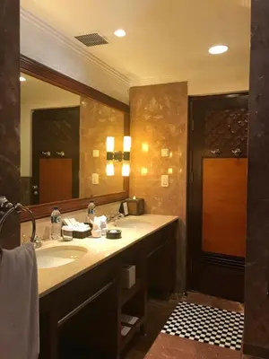 a bathroom with a sink and a large mirror at Villas at The Patra Bali Resort and Villas - CHSE Certified in Kuta