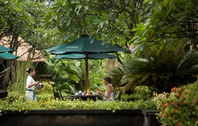 two people sitting at a table under an umbrella at Villas at The Patra Bali Resort and Villas - CHSE Certified in Kuta