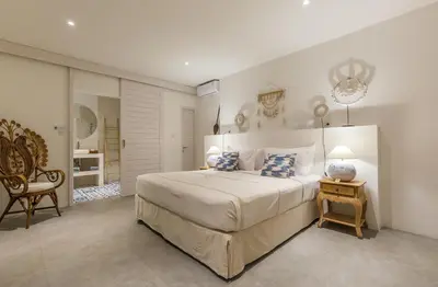 a bedroom with a large bed and a chair at Villa soul in Seminyak