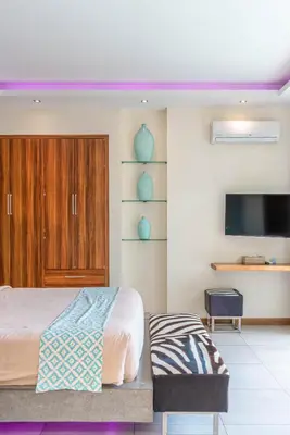 a bedroom with a bed and a flat screen tv at Villa Sawah - 3bd in Seminyak Center in Seminyak