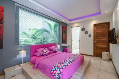 a bedroom with a pink bed and a large window at Villa Sawah - 3bd in Seminyak Center in Seminyak
