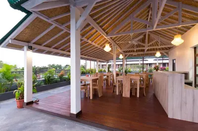a restaurant with wooden tables and chairs on a deck at Amerta Seminyak in Seminyak