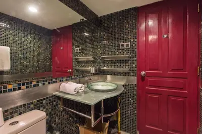 a bathroom with a sink and a red door at Sejuk Suites in Legian