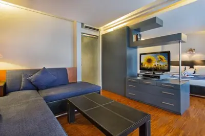 a living room with a couch and a bed at Sejuk Suites in Legian