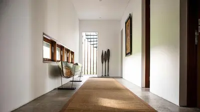 a hallway with white walls and a door with a rug at Villa Indrani in Canggu